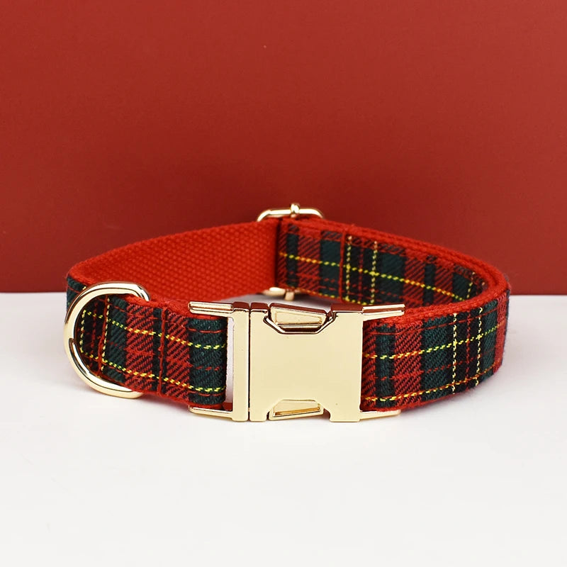 A red plaid dog collar with a gold buckle displayed against a solid red background.