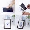 A set of pet paw print and handprint supplies including a display board, framed prints, and paper for creating impressions.