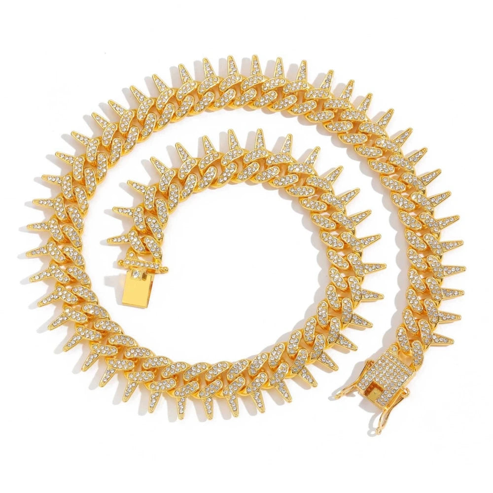 A gold spiked Cuban chain bracelet adorned with diamond accents.