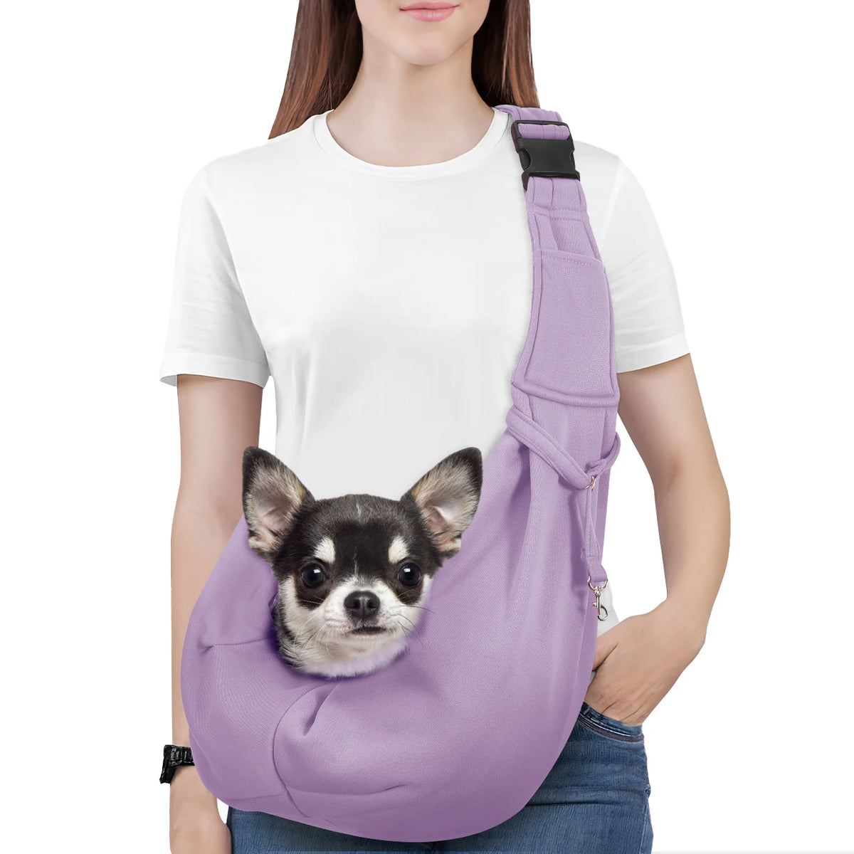 A woman is wearing a purple reversible hands-free dog sling carrier with a black strap and denim jeans.