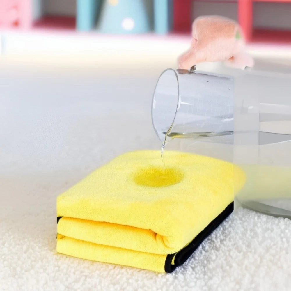 A yellow ultra-absorbent pet drying towel is shown dripping water into a clear glass container.