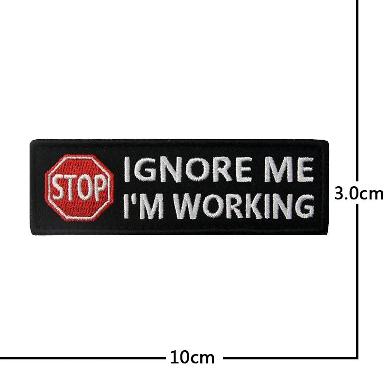 Black embroidered patch with red stop sign and text that reads IGNORE ME I'M WORKING
