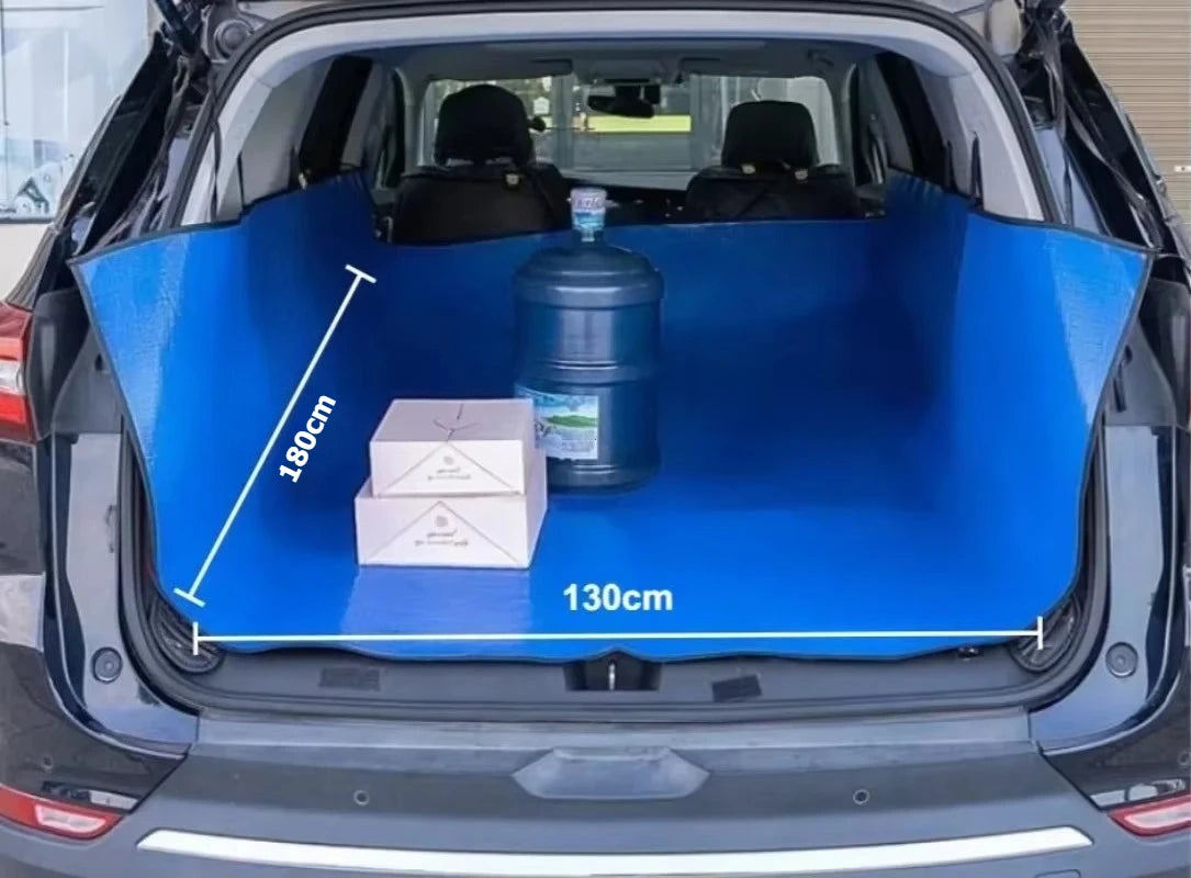 A blue waterproof car trunk mat with a pet barrier is shown inside the trunk of a car.