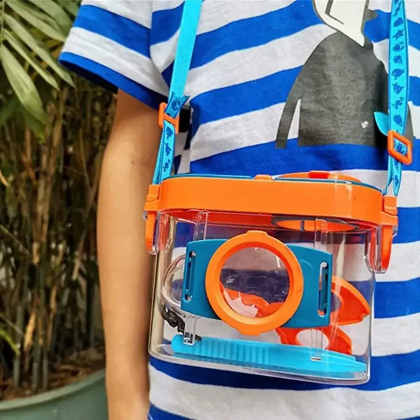 An insect observation box with dual orange and blue magnifiers is attached to a strap, worn on a person's shirt.