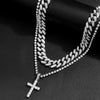A close-up of a dainty diamond Cuban link necklace set featuring a cross pendant.