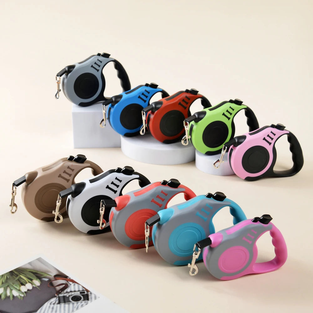 A collection of pink, green, black, and orange retractable dog leashes are displayed on a light background.