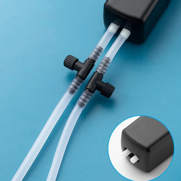 A clear silicone tube connects a compact USB aquarium air pump to an air stone.