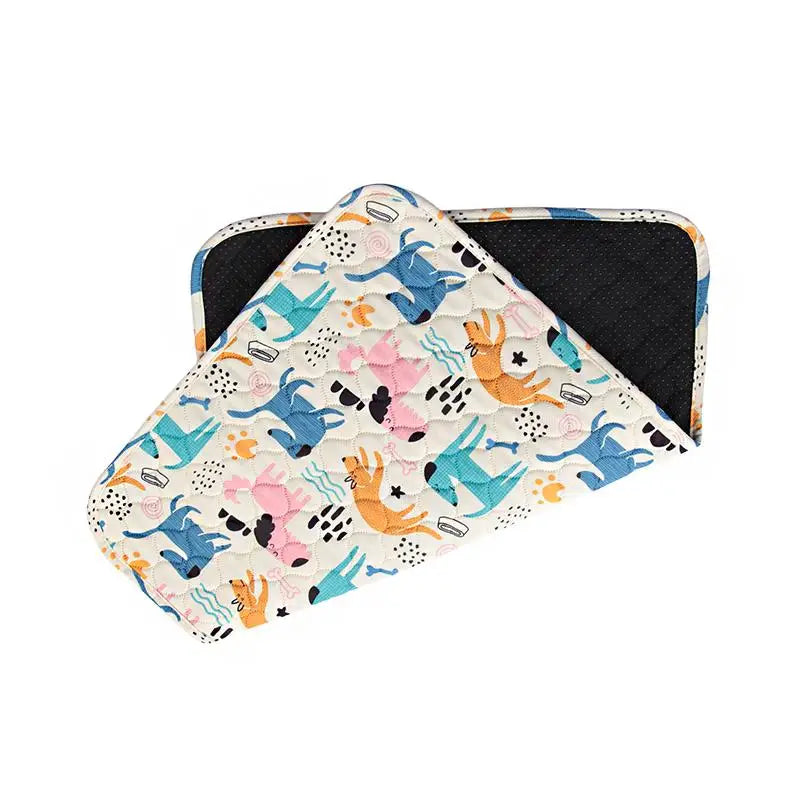 A folded washable non-slip dog training pad featuring a colorful pattern of blue, orange, and pink animal silhouettes.