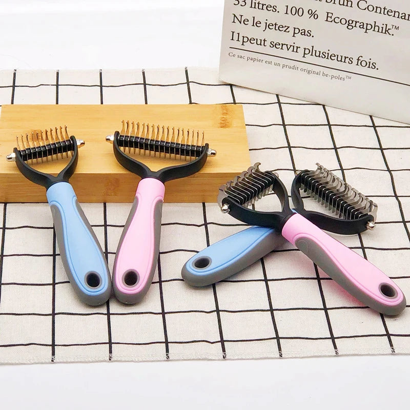 A set of five stainless steel pet dematting combs in various colors resting on a wooden block and a white grid surface.