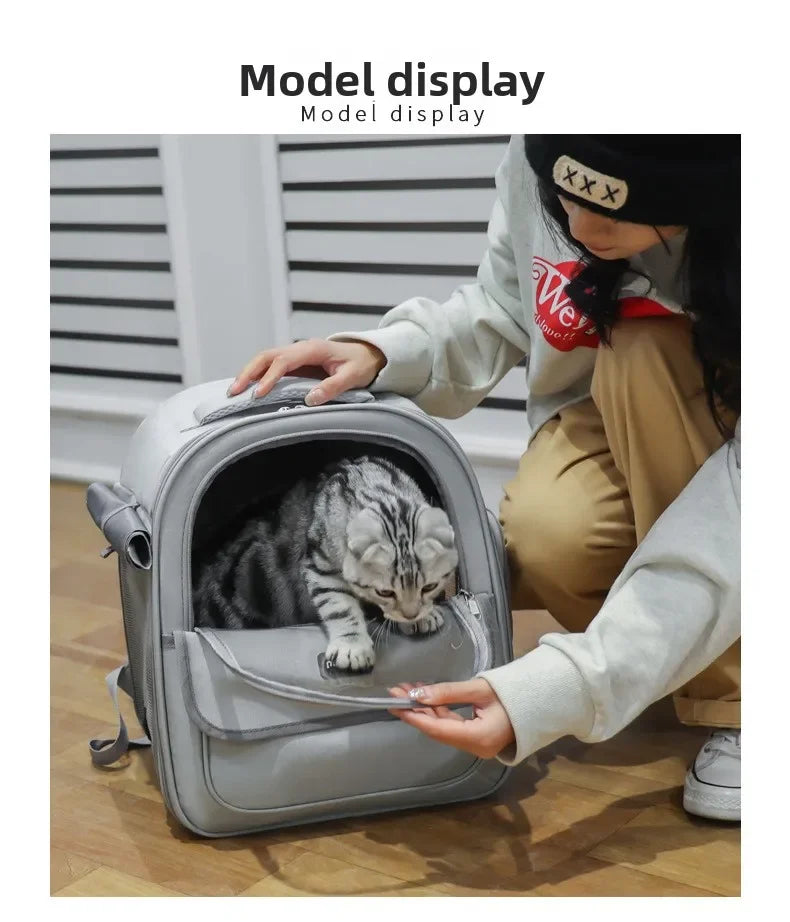 Eine Frau zeigt einen grauen, atmungsaktiven Hundetransporter-Rucksack mit einer Katze darin.