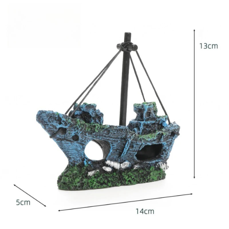 A dark blue and green aquarium ornament shaped like a shipwreck with a cave hideout, suspended by black string.