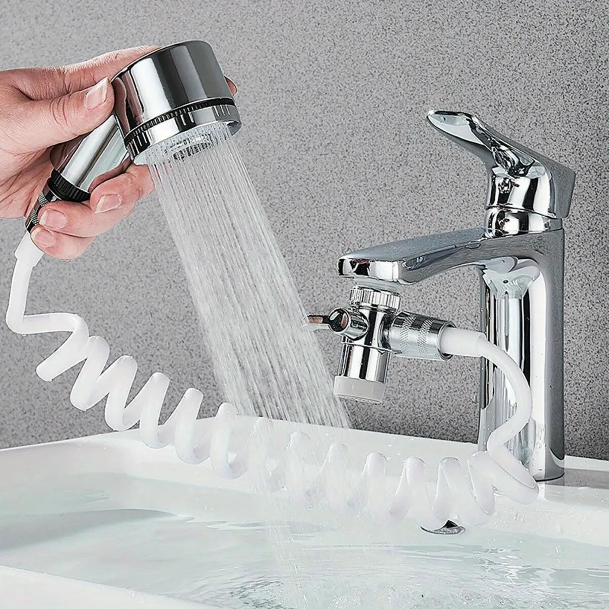 Une main utilise un diffuseur de lavabo ajustable pour projeter de l'eau dans une bassine.