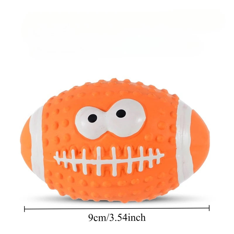 An orange squeaky latex ball for dogs with a white stitched pattern and large eyes.