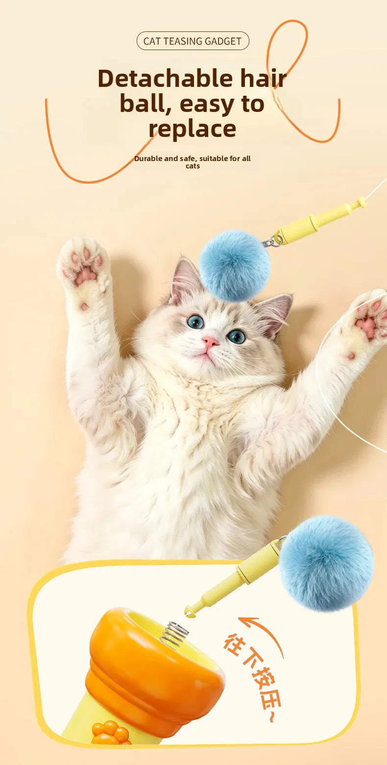 A fluffy white kitten is shown interacting with a detachable hair ball toy and an electric wand for cat teasing.