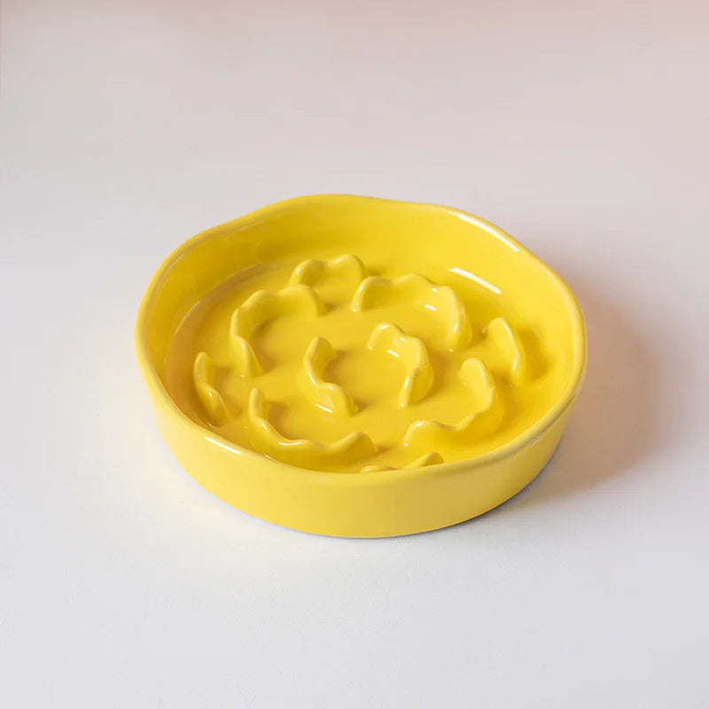 A bright yellow ceramic pet bowl with a raised neck design is shown on a white surface.