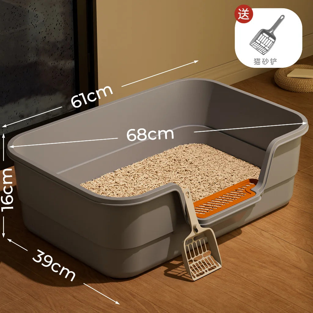 A large grey semi-enclosed cat litter box with an orange scoop is shown on a wooden floor.