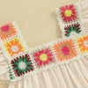 A light pink toddler romper featuring colorful floral embroidery with pink, yellow, and green accents.