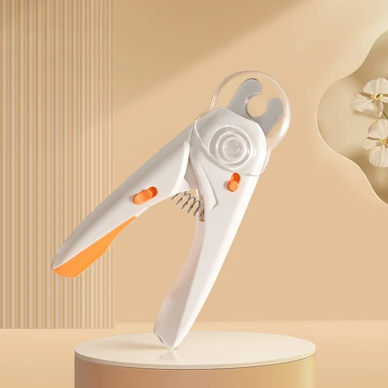 A white safety guard pet nail clipper for dogs and cats is displayed on a light-colored surface.