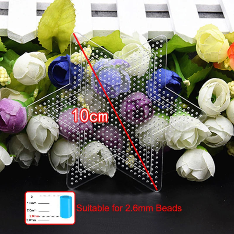 A set of precision tweezers used for handling 2.6mm beads, shown with a scale and surrounded by white and purple flowers.