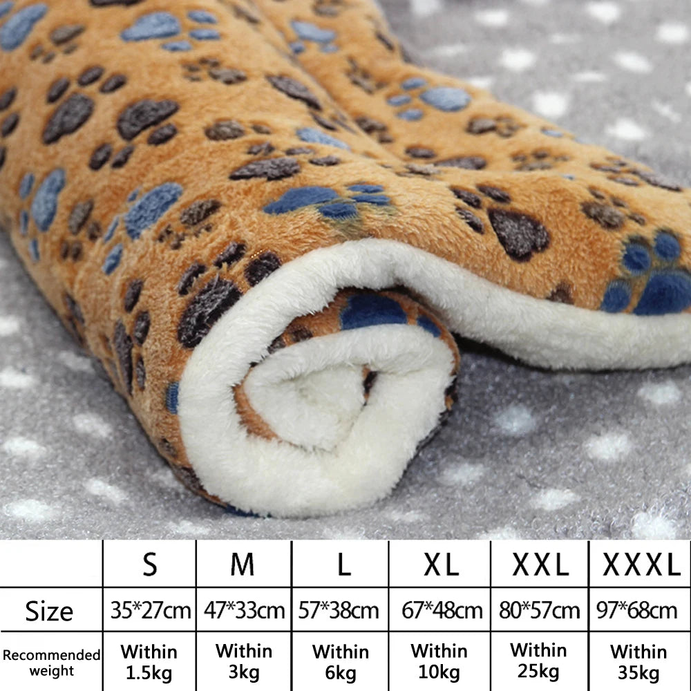 Lit pour animal à carreaux orange et bleu roulé avec bordure blanche, sur surface grise.