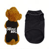A fluffy golden dog toy wearing a black vest with the text Mama's Boy on it.