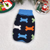 A navy blue knitted dog sweater with light blue and orange paw print patterns is displayed on a white background.