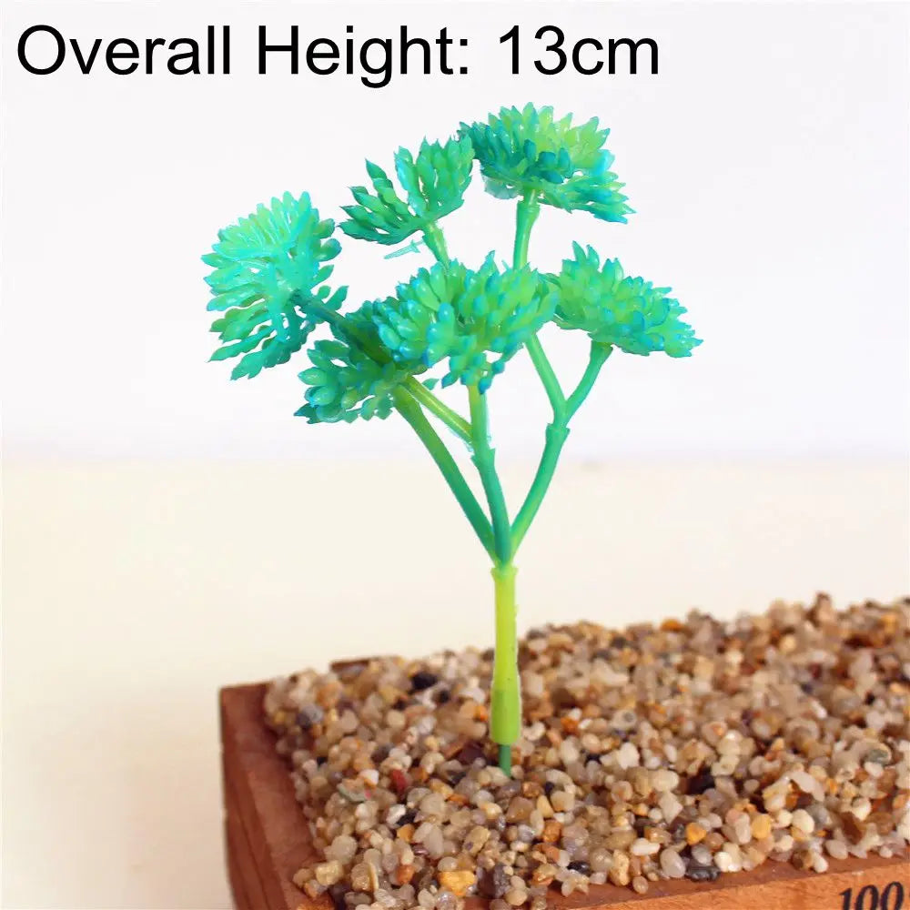 A bright green artificial succulent plant with 13cm height is displayed in a wooden tray filled with small pebbles.