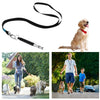 A black adjustable ultrasonic dog whistle attached to a leash, shown next to a golden retriever.