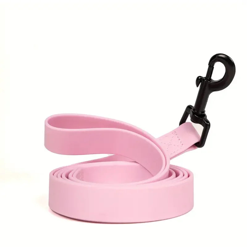 Pink waterproof PVC dog leash with a black clip and coiled in the foreground.