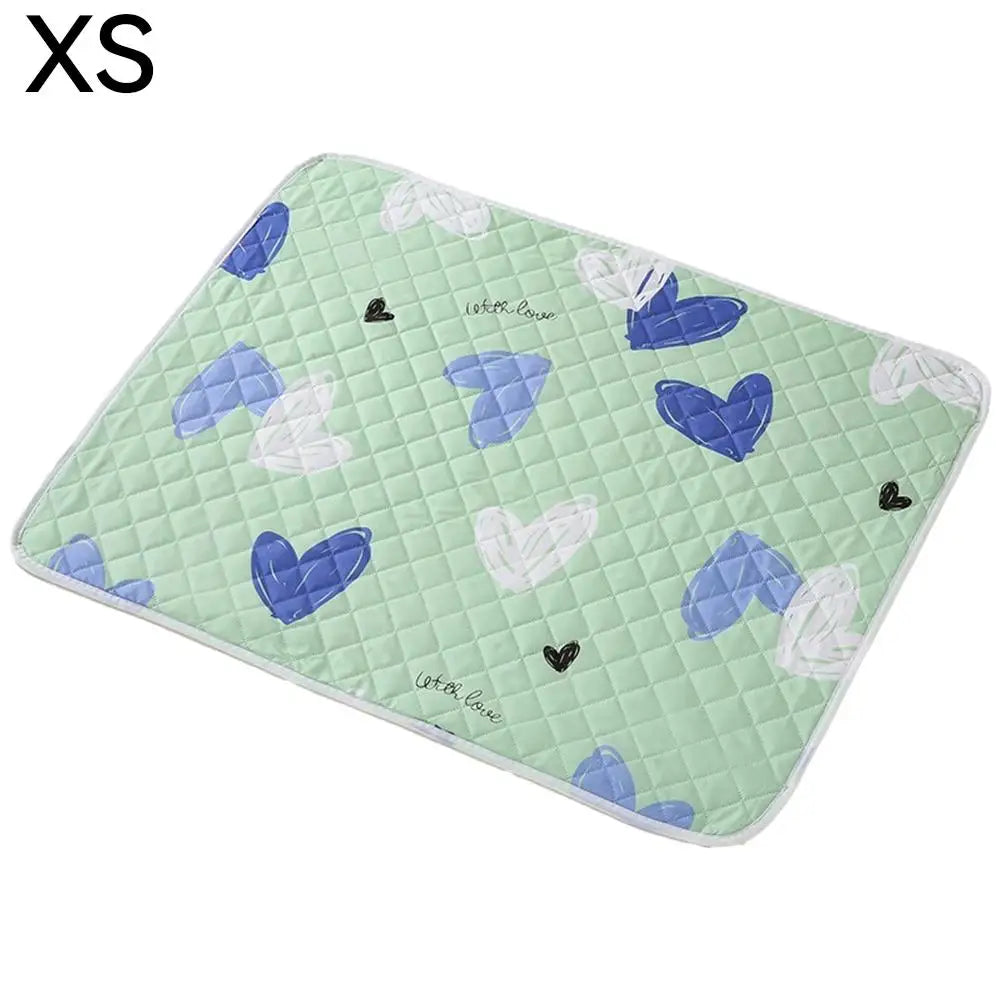 A light green reusable washable pet urine pad featuring blue and white heart-shaped designs.