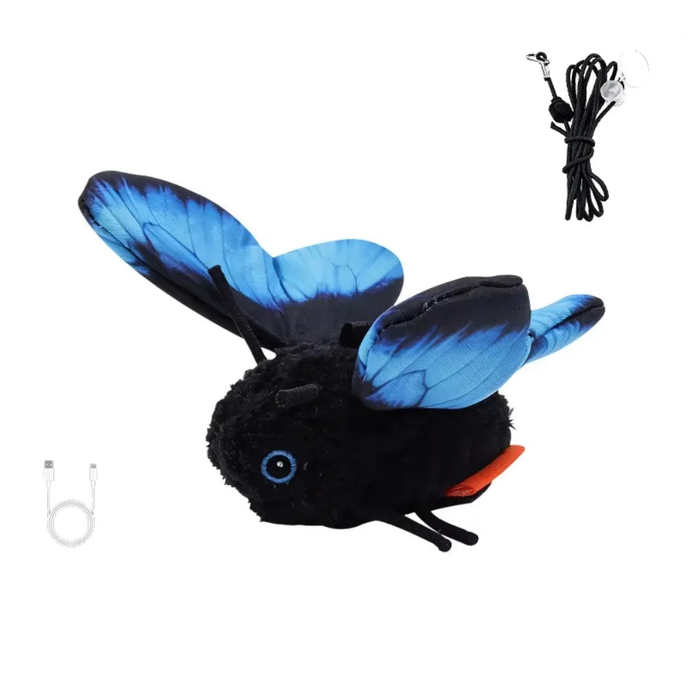 A black stuffed animal toy resembling a bat with blue butterfly wings and a wire attached.