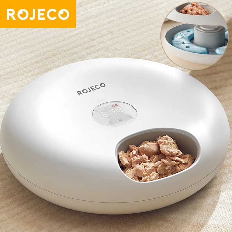 Rongeur automatique blanc ROJECO avec compartiment ouvert contenant de la nourriture pour animaux.