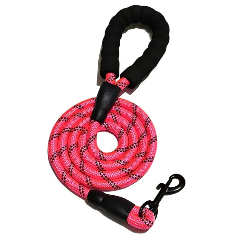 A bright pink reflective dog leash with a padded handle and black grip is shown coiled.
