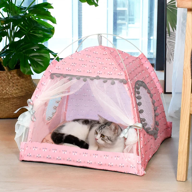 Un lit pour animal de compagnie en forme de fleur rose semi-clos, avec un dessus en filet, contenant un chat gris et blanc.