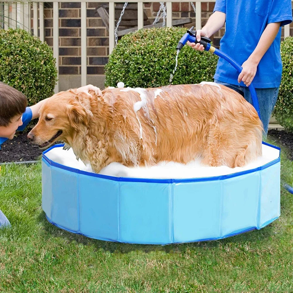 A person is filling a blue inflatable pet swimming pool with foam for dogs and cats outdoors.