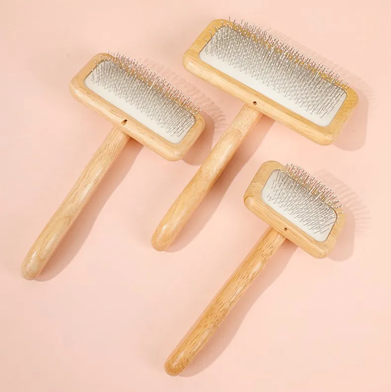 Two wooden pet grooming brushes with massage bristles lying on a light pink background.