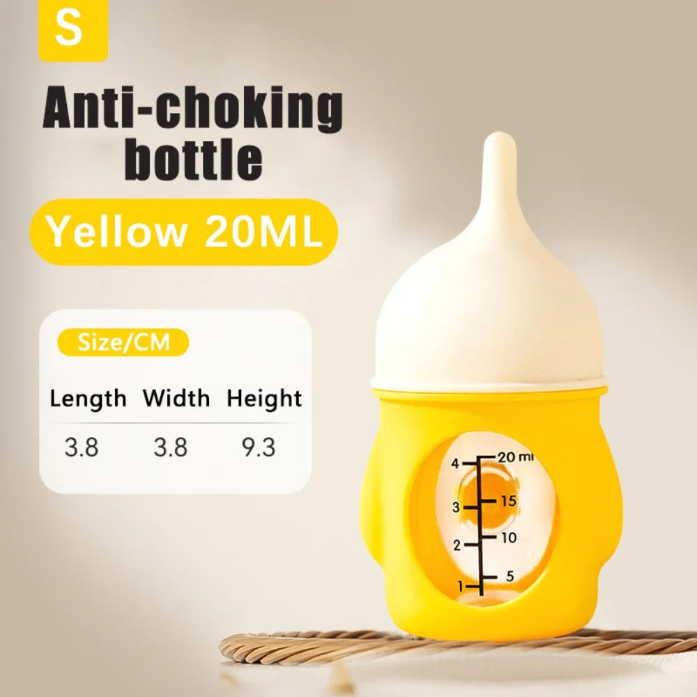A yellow silicone pet nursing bottle with a white anti-choking nipple and measuring markings is shown on a wooden surface.