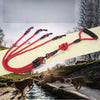 A red and black 2-way dual dog leash coupler is shown with two dogs near a stream.