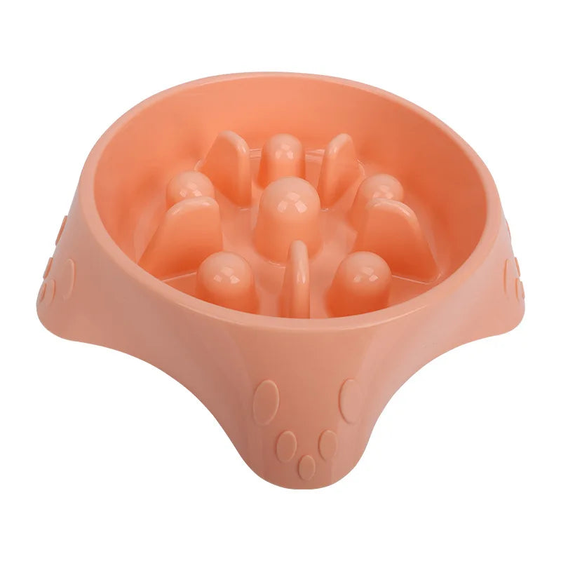 A pink slow feeder dog bowl with raised silicone puzzle pieces for feeding.