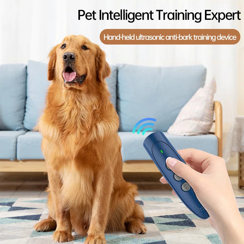 A hand holds a blue ultrasonic anti-bark training device near a golden retriever dog.