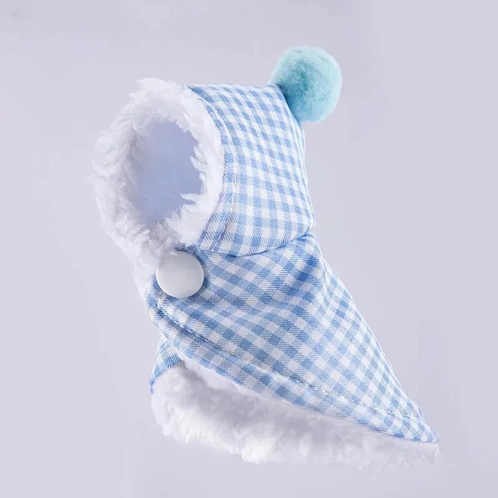 A light blue plaid parrot cape and hat set with white fluffy trim and a teal pom-pom.