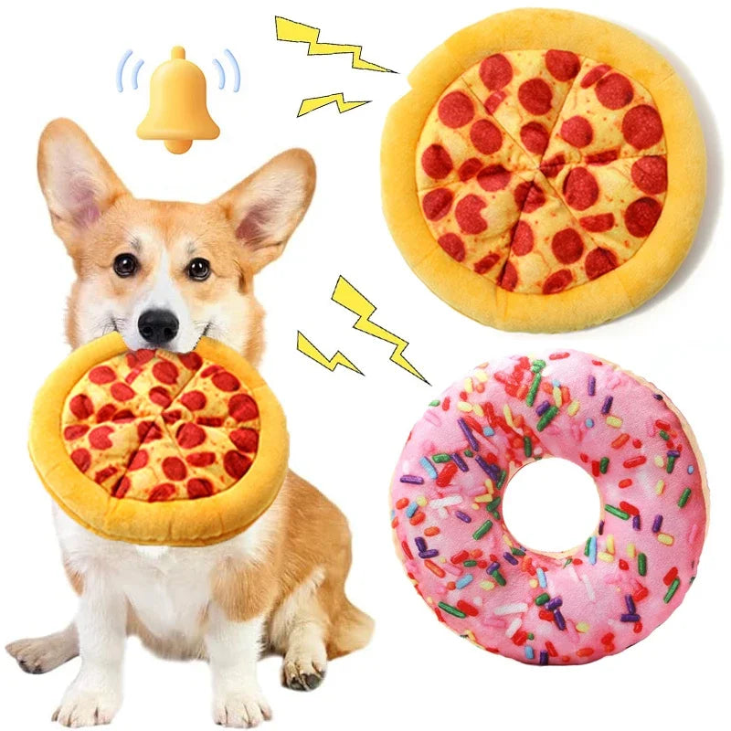 Un chien interagit avec des jouets en peluche en forme de pizza et de beignet, suggérant un jouet à siffler.