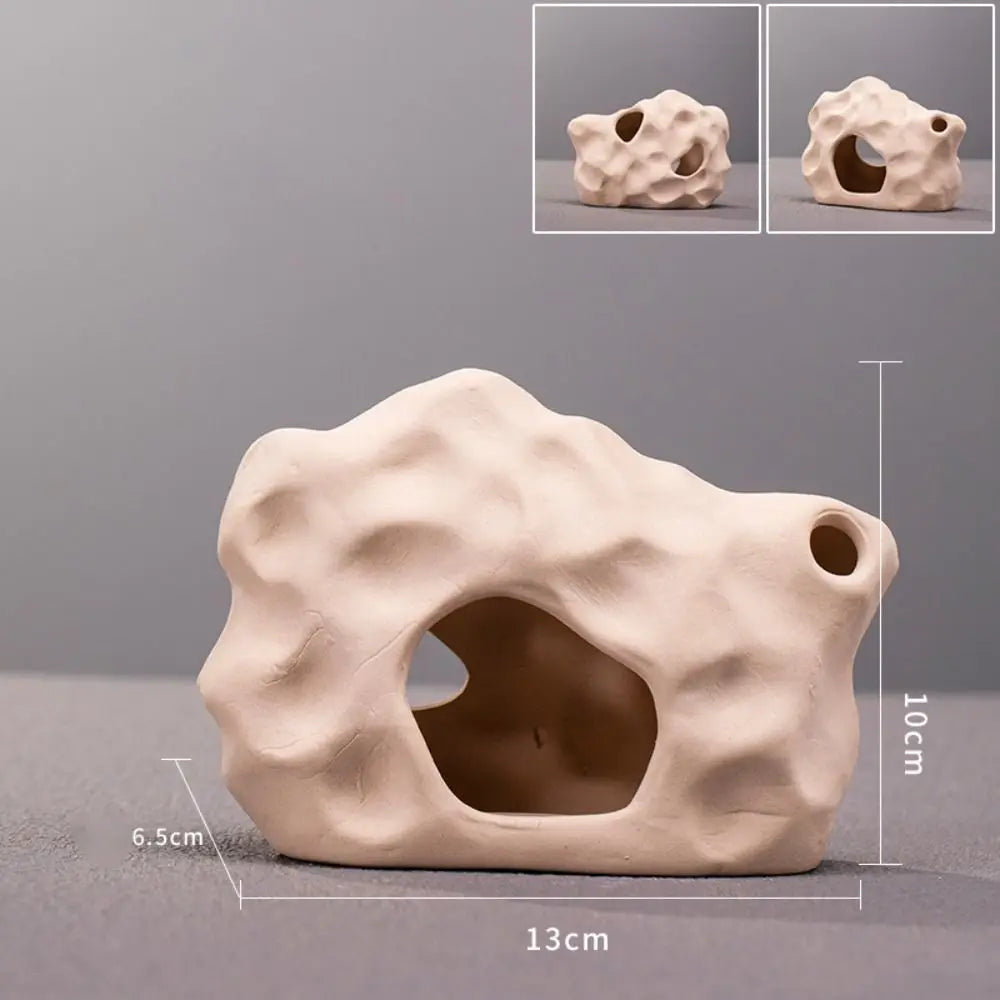 A beige ceramic aquarium shrimp hideaway cave with a natural, textured surface and an entrance hole.