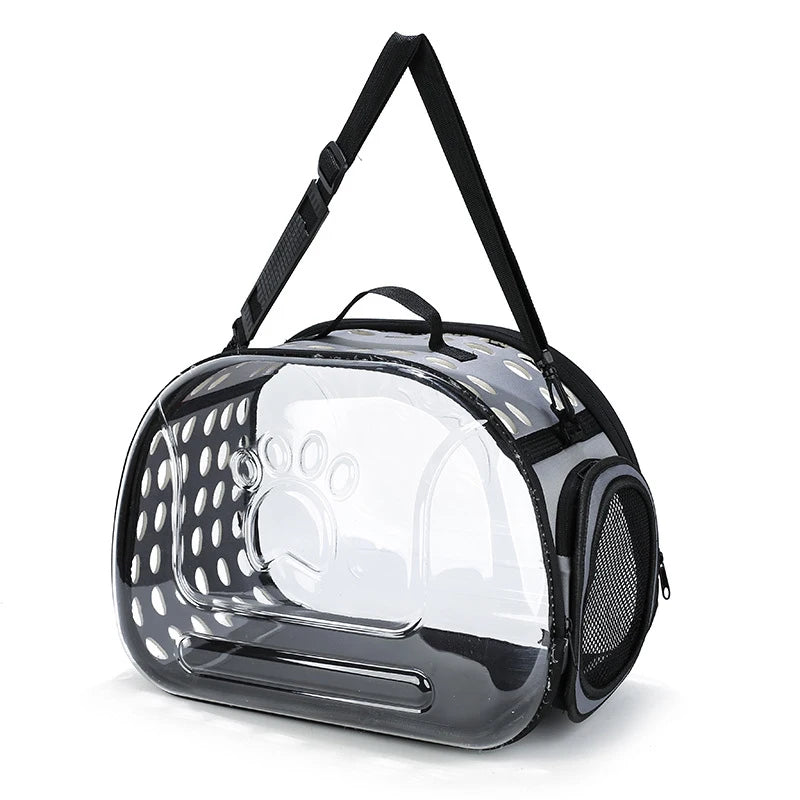 A clear, foldable pet travel carrier with a black shoulder strap is shown from the front.