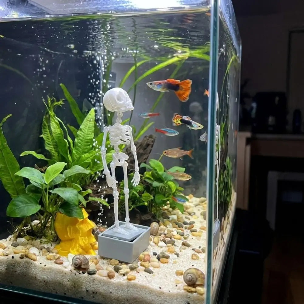 A clear glass aquarium featuring a dancing skeleton decoration amidst green aquatic plants and gravel.