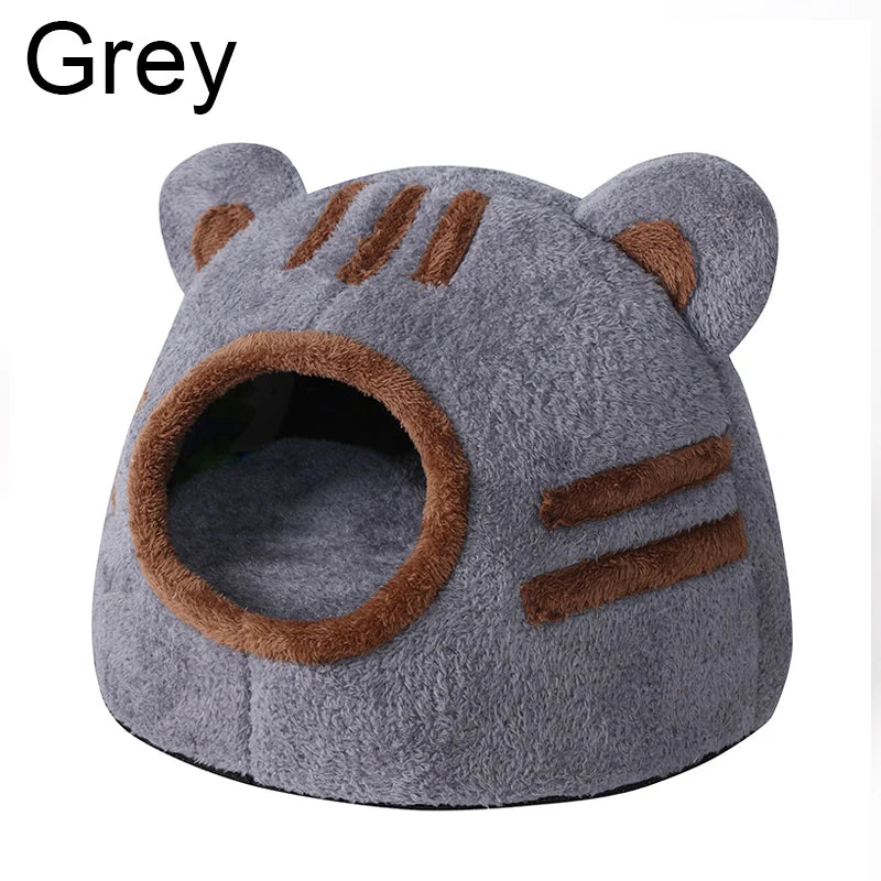 Graues, stuffedes Katzenbett in Form eines Bärenkopfes mit Streifen und Eingangsloch.