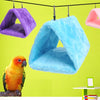 A bright blue plush hanging bird hammock bed is suspended against a lime green background.