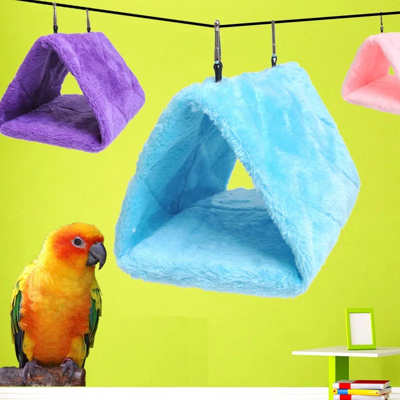 A bright blue plush hanging bird hammock bed is suspended against a lime green background.