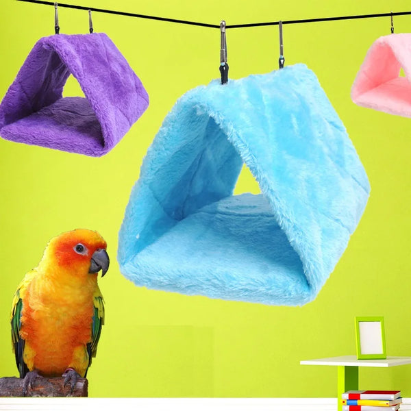 A bright blue plush hanging bird hammock bed is suspended against a lime green background.