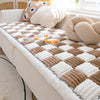 A cozy plush fleece pet bed mat with a beige and brown diamond pattern is displayed on a light-colored sofa.